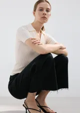 Jeans wide leg negros de tiro medio, con diseño de pernera ancha y terminación desmechada en el bajo.