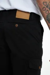 Pantalón cargo gris de gabardina, corte slim, con bolsillos laterales con solapa y bolsillos traseros con ojal y botón. Presenta efecto teñido en la tela.