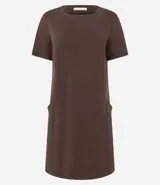 Vestido corto marrón oscuro, estilo camiseta, con escote redondo, mangas cortas y bolsillos laterales. El bajo es redondeado.