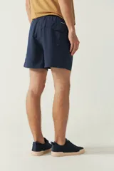 Short de baño liso color coral con cintura elástica, cordón ajustable, dos bolsillos laterales y uno trasero.