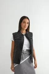 Chaleco de denim acolchado con efecto lavado, diseño sin mangas, cierre frontal y bolsillos laterales.