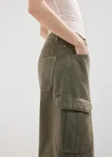Pantalón cargo de jean color verde militar, de tiro medio, corte ancho y bolsillos laterales con solapa.
