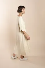 Vestido midi acampanado de lana fina sin teñir, con cuello bote, mangas tres cuartos con tajo y bolsillos laterales. Diseño forrado con vuelo y movimiento.