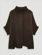 Capa tejida color fucsia, con cuello alto abotonado y mangas cortas estilo japonesa. Tejido de punto grueso.