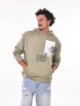 Buzo con capucha (canguro) color verde militar, corte holgado, con bolsillo canguro frontal y estampado gráfico en el pecho.