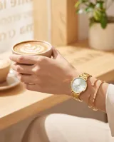 Reloj analógico para mujer con caja y malla de acero inoxidable en color dorado. Presenta una esfera minimalista con fondo blanco y marcadores de hora lineales.