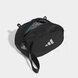 Bolso deportivo pequeño tipo pouch de color negro, con forma ovalada y logo Badge of Sport de Adidas reflectante en el centro. Cuenta con correa ajustable y removible.