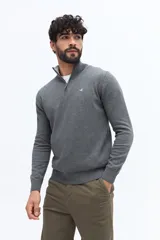 Sweater de tejido de punto color gris oscuro, con cuello medio y cierre parcial frontal. Presenta puños y ruedo acanalados, y un pequeño logo bordado en el pecho.