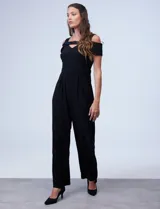 Enterito largo negro de seda fría, marca RM Richards. Presenta escote asimétrico y mangas cortas con detalle de brillos. Espalda con abertura central y cierre invisible.