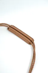 Cartera de mano negra con flecos largos colgantes y correa delgada.