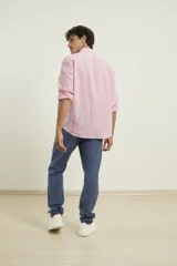 Camisa de manga larga confeccionada en una mezcla de algodón y lino, con cuello abotonado, cierre frontal de botones y un bolsillo en el pecho.