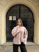 Polerón de cuello alto en color rosa, con diseño de calce holgado y mangas amplias. Confeccionado en tela suave y abrigada, ideal para un estilo urbano y relajado.