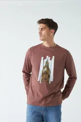 Remera marrón de manga larga con estampa de la torre del reloj Big Ben de Londres y líneas verticales blancas. Corte recto y cuello redondo.