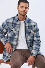 Campera tipo leñadora de viyela a cuadros, con interior forrado en corderito para mayor abrigo. Presenta cierre frontal con botones, cuello clásico y dos bolsillos frontales con solapa y botón.