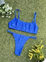 Conjunto de bikini azul francia, con corpiño tipo top y colaless regulable, confeccionado en tela lurex brillante.