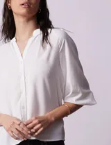 Blusa de gasa estampada en tonos azules y negros, marca Sioni. Tiene cuello a la base con escote en V, abertura central con botones y mangas tres cuartos fruncidas.