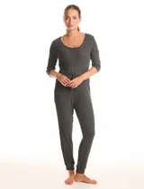 Enterito de tejido de punto con textura canalé, color gris oscuro. Presenta escote redondo, mangas tres cuartos y cintura elastizada con lazo de ajuste. La parte inferior tiene un calce relajado tipo jogger con puños elastizados y bolsillos laterales.