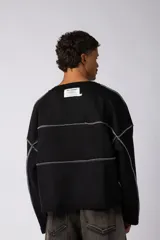 Buzo oversize de corte boxy, confeccionado en algodón rústico de alto gramaje en color beige. Presenta cuello redondo con borde crudo, mangas largas y una estampa frontal con el texto VCP delimitado por líneas horizontales blancas.