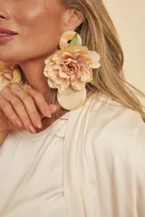 Aros colgantes formados por una pieza superior circular marmolada, una gran flor de tela en tonos beige y salmón, y una pieza inferior circular texturada.