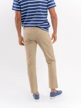 Pantalon tipo chino de corte recto, color beige, con cierre frontal y bolsillos laterales.