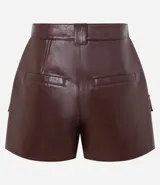 Short pollera de tiro medio confeccionado en poliuretano con acabado símil cuero. Presenta diseño de corte recto, cierre frontal con cremallera, trabillas para cinturón y dos bolsillos delanteros con solapa.