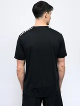 Remera deportiva Umbro de manga corta, color negro con detalles de líneas blancas en los hombros y logo de la marca estampado en el pecho.