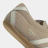 Championes Adidas modelo Tokyo de corte bajo y diseño retro. Confeccionados en gamuza color beige con las icónicas tres tiras laterales en color crema y suela de caucho natural.