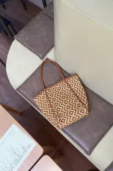 Bolso tipo tote de cuero trenzado color tostado con diseño geométrico.