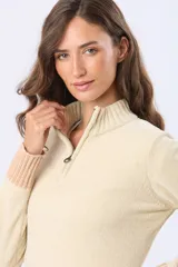 Buzo tejido combinado de color beige, con cuello alto, medio cierre metálico y puños y ruedo acanalados en tono tostado.