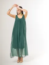 Vestido largo de seda italiana en color verde inglés, con tirantes anchos, escote redondo y diseño holgado con frunces. Cuenta con forro interior de viscosa elastizada.