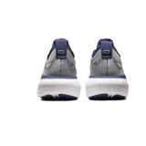Championes de running Asics Gel Nimbus 25, color gris con detalles en azul marino y suela blanca. Presentan tecnología PureGEL en el talón y amortiguación FF Blast+ en la entresuela para mayor confort.