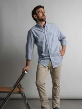 Camisa de corte regular confeccionada en algodón, con diseño de rayas verticales en tonos azul y blanco. Presenta cuello con botones, cierre frontal abotonado, bolsillo en el pecho con logo bordado y mangas largas.