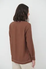 Blusa azul marino de corte recto y holgado, con escote en V y mangas largas. Presenta detalles de costuras a la vista en color blanco en el escote, puños y ruedo.