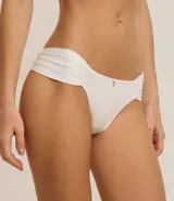 Kit de dos bombachas bikini de microfibra, color blanco y amarillo, con laterales drapeados y detalle de dije dorado.