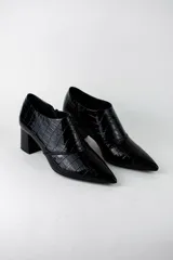 Botines de mujer con textura efecto croco y acabado acharolado. Presentan un diseño de punta fina, cierre lateral y taco cuadrado de altura media.