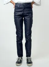 Pantalón negro de corte recto, estilo jean, con acabado engomado que simula cuero.