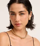 Conjunto de collar corto y caravanas de metal dorado con diseño de esferas lisas.