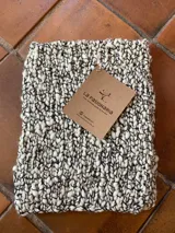 Cuello tejido a mano en pura lana merino color blanco y negro. Tiene tajos a los costados.