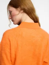 Sweater de punto de cachemira color turquesa con cuello polo y cierre frontal de tres botones. Presenta una textura suave tipo pelo, manga larga y terminaciones acanaladas en puños y ruedo.