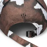 Gorro de visera Nike Nocta color marrón con estampado abstracto en tonos marrones y blancos. Logotipo de Nocta bordado en el lateral.