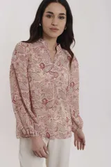 Blusa estampada con motivos cachemira en tonos crudo y rojo, con cuello mao y cierre frontal con botones.