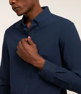 Camisa de manga larga en tejido oxford de algodón color blanco, con cuello tradicional y cierre frontal de botones.