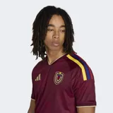 Camiseta de fútbol Adidas de la selección de Venezuela, modelo Primera Equipación 26. Color principal granate con detalles en amarillo dorado en cuello y hombros. Presenta un estampado integral sutil con textura.
