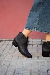 Botines texanos negros de cuero con puntera fina y taco bajo.