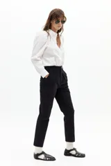 Camisa blanca de algodón con cuello mao, hombros abullonados y mangas largas. Cierre frontal con botones de nácar.