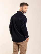 Camisa marrón de pana con cuello abotonado, manga larga con puños abotonados, corte regular fit y bolsillo en el pecho.