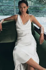 Vestido largo de tejido satinado con escote asimétrico, tirante ancho y tirante fino cruzado en la espalda. Presenta un diseño fluido con forro interior a tono.