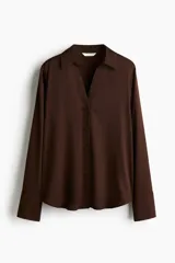 Blusa de manga larga color marrón oscuro, con cuello clásico y escote en V profundo, cierre frontal de botones y puños anchos.