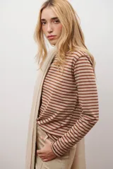 Remera de manga larga con diseño de rayas horizontales en azul y blanco, destacada por un cuello redondo en color bordó con costuras a la vista.