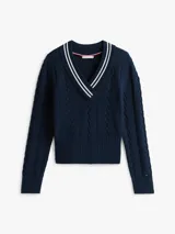 Sweater de punto color azul marino, con cuello en V ribeteado con dos franjas blancas. Presenta tejido trenzado (cableado) en el frente y puños y dobladillo acanalados.